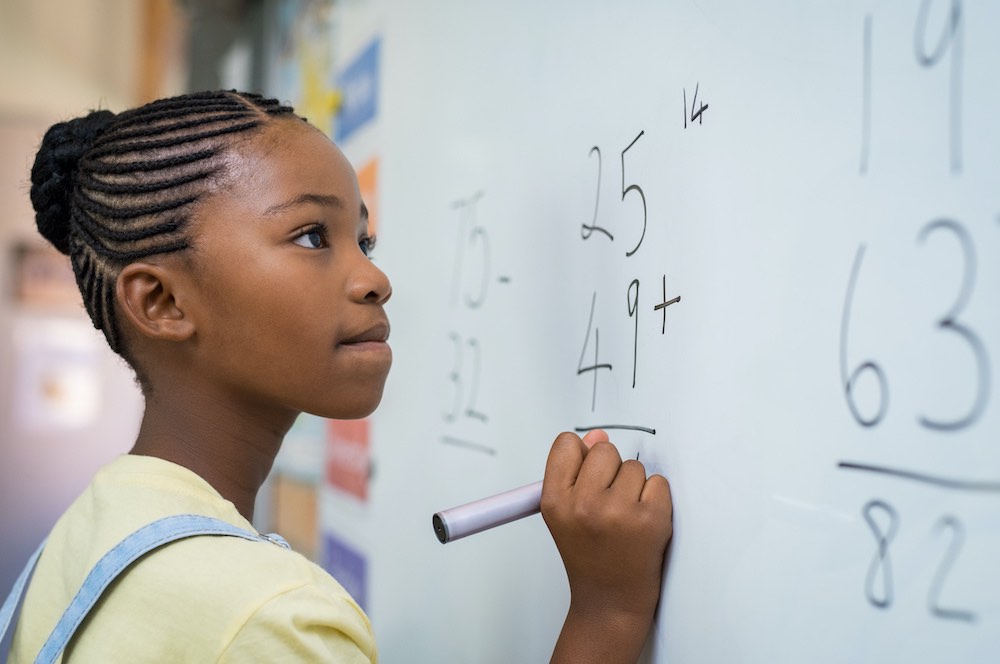 girl writing at board